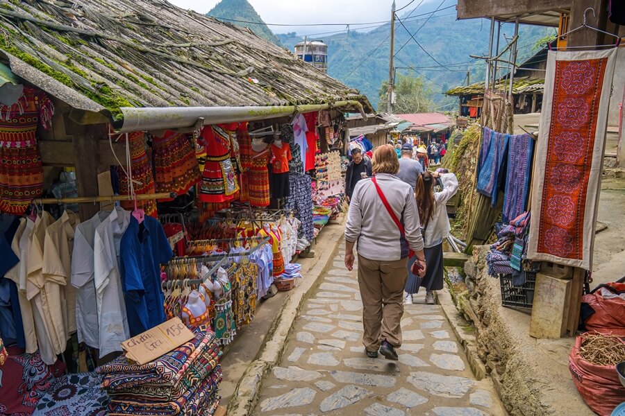Traveler walking along a scenic path toward Cat Cat Village in Sa Pa