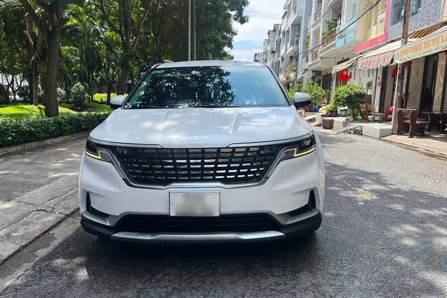 Modern white Kia Carnival with luxury seating, viewed from the front