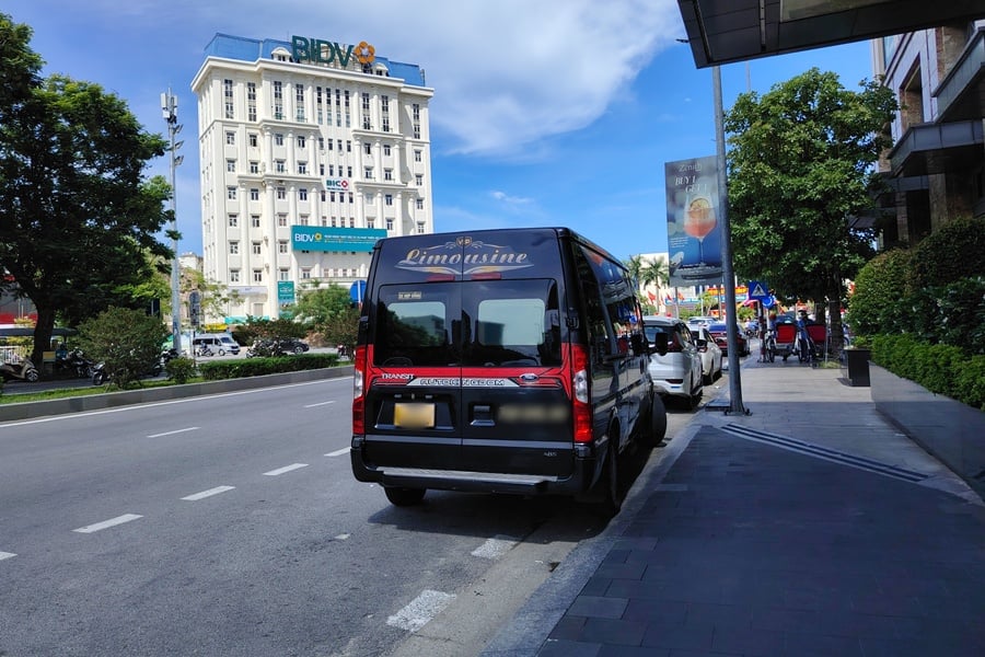 DCar Limousine van parked in front of a hotel, waiting for guests, available for rental in Vietnam