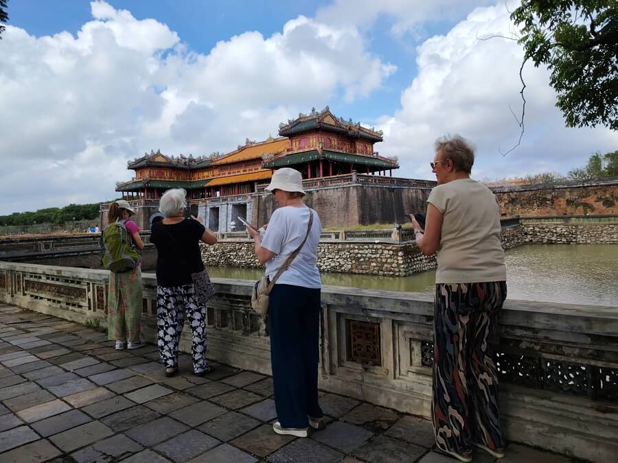 A female tourist group takes pictures at the Hue Citadel in Vietnam
