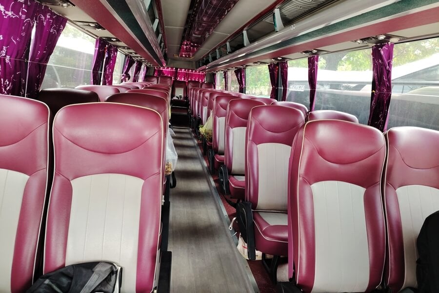 Interieur van een 45-persoonsbus in Vietnam met lederen stoelen en een ruime middengang