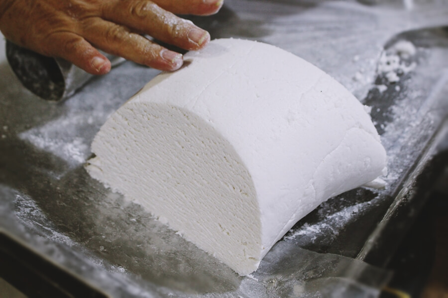 A Vietnamese woman preparing dough for traditional noodles – representing the craft of Vietnamese cuisine