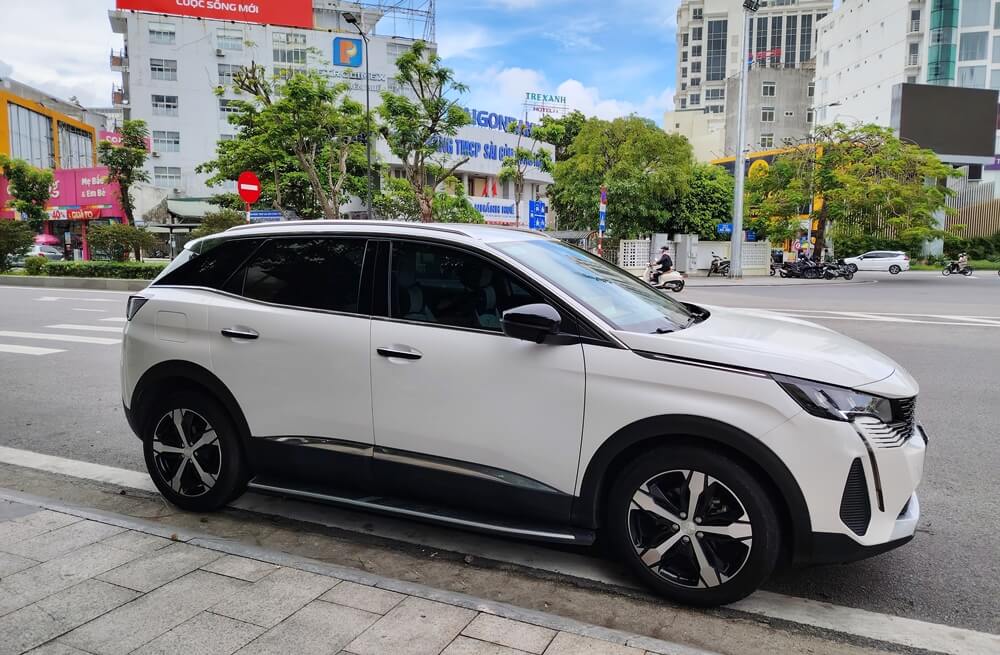 White car waiting for passengers at a hotel in Vietnam, a common city transportation option