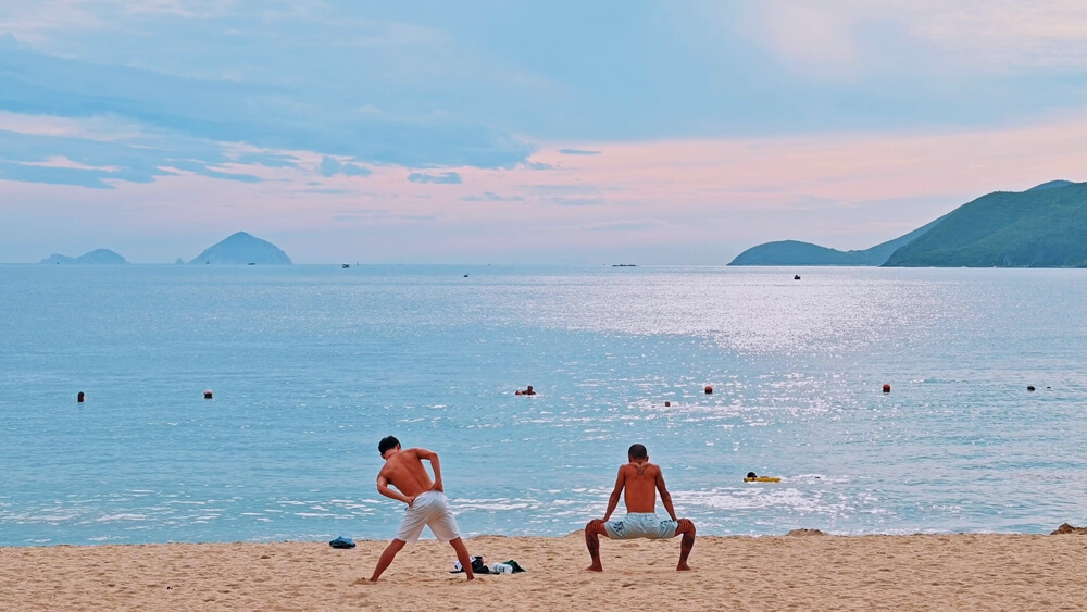 Sunrise at Nha Trang Beach with locals swimming and exercising