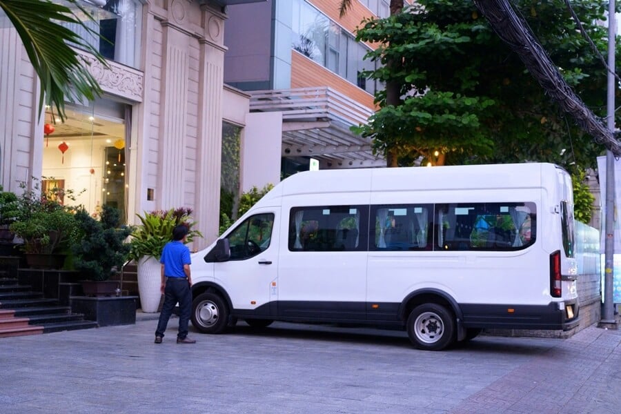16-seater private van waiting at a hotel in Ho Chi Minh City for transfer to Mui Ne