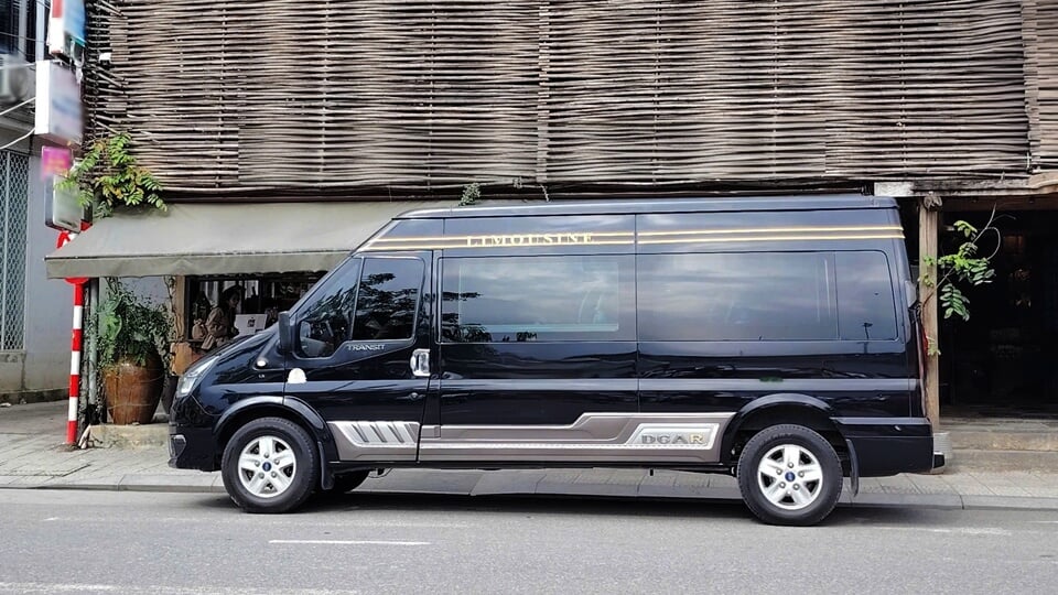 Black DCar Limousine van with silver bodykit and gold accents waiting for guests, representing luxury travel services