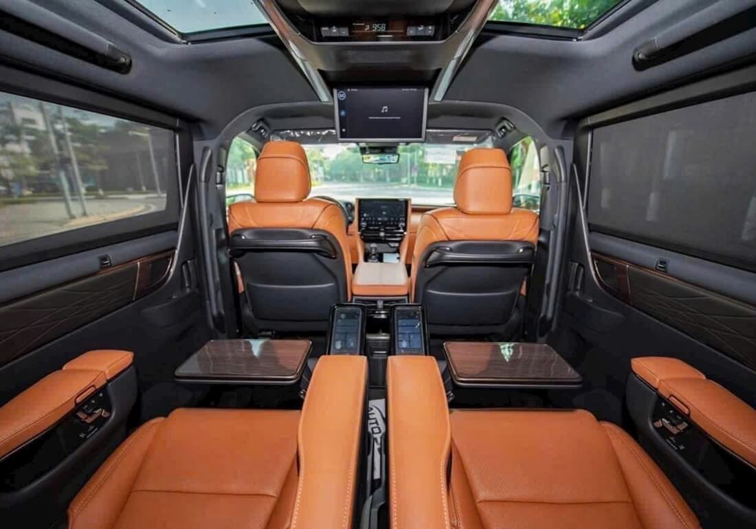 Full interior view of Toyota Alphard featuring work tables, entertainment screens, and sunroof