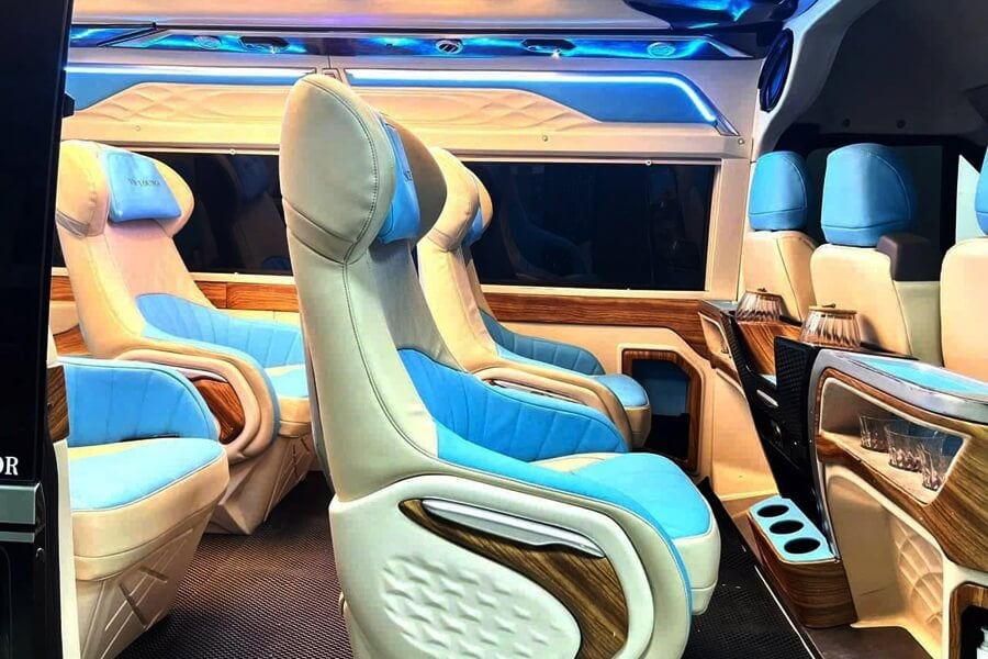 Premium reclining captain seats with leather upholstery and ambient lighting inside a luxury limousine van for private travel in Vietnam