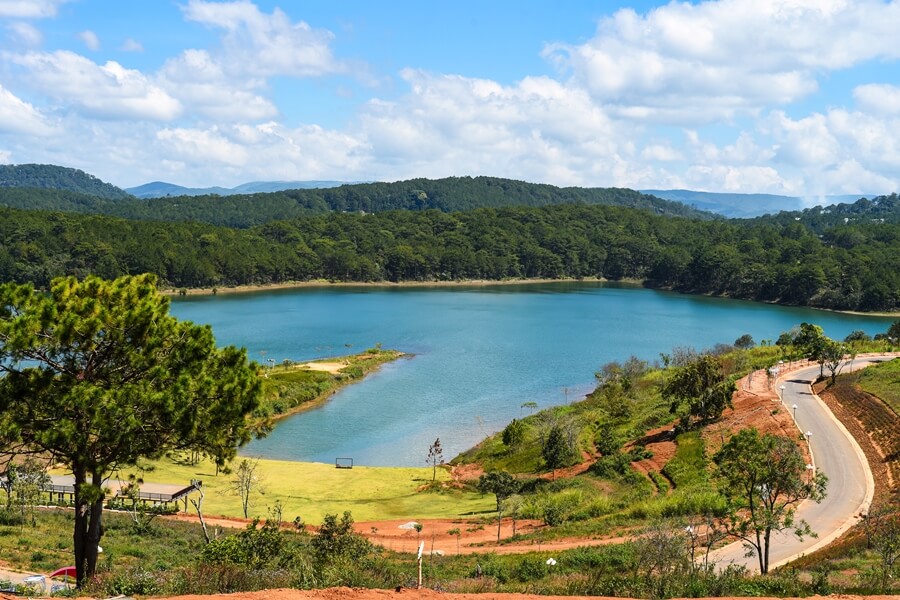 Scenic road by a lake in Da Lat, Vietnam, representing diverse private car travel routes