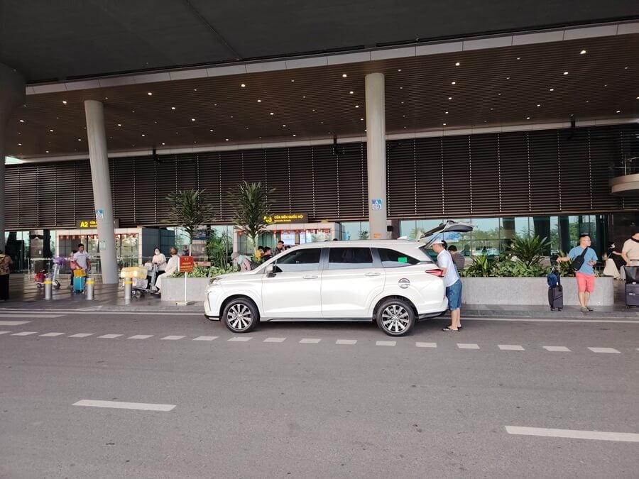 Driver loading luggage into the trunk during private airport pickup in Vietnam
