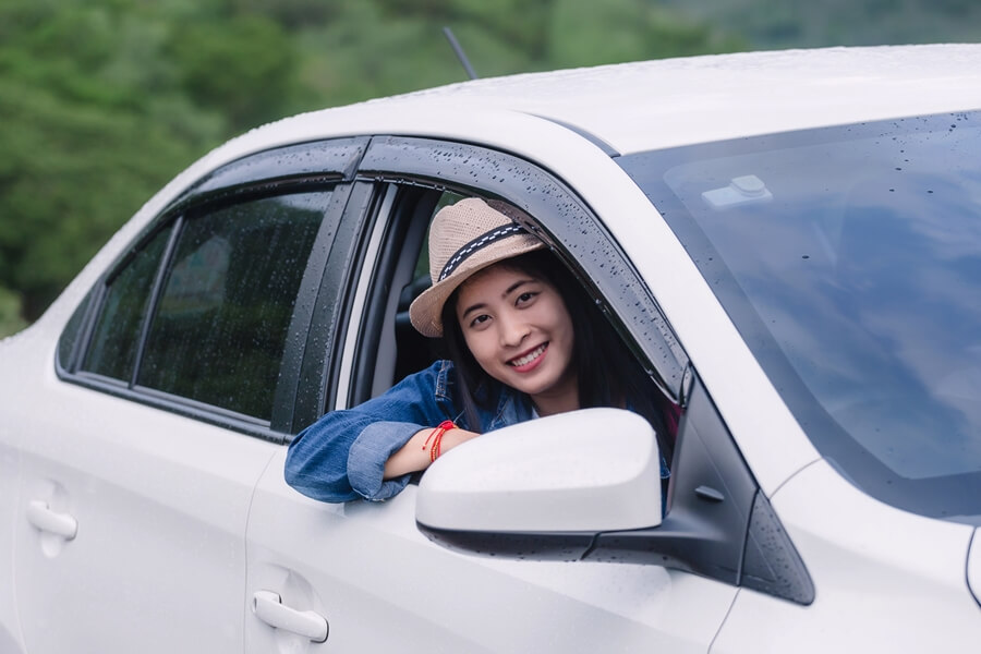 Passenger enjoying the view from a private sedan while traveling through the Mekong Delta