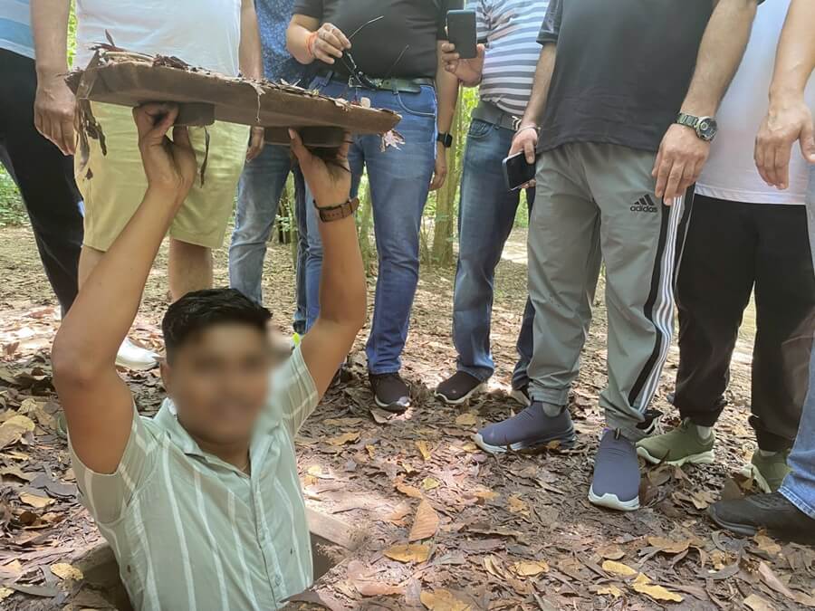 Visitor entering a narrow tunnel at the Cu Chi Tunnels during a day trip from Ho Chi Minh City