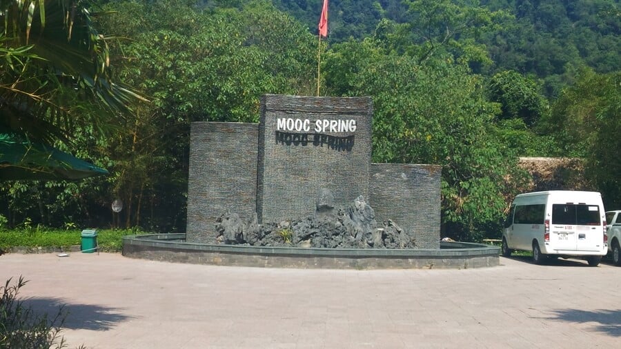 Private car waiting beside the Mooc Stream entrance sign in Phong Nha