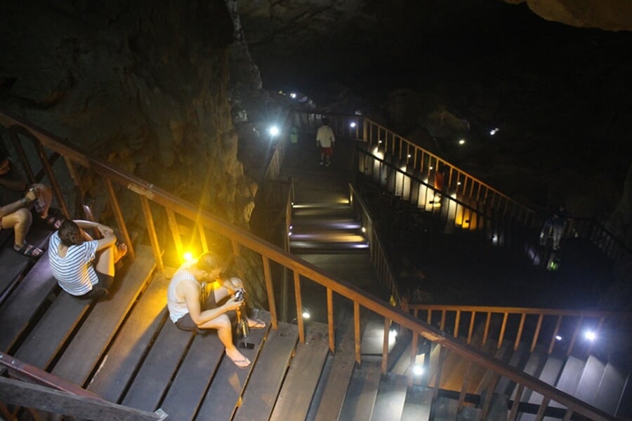 Wooden boardwalk descending from the entrance of Paradise Cave with visitors resting on the stairs