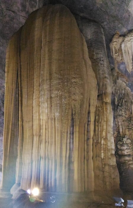 Tall stalagmite rising from the cave floor in Paradise Cave