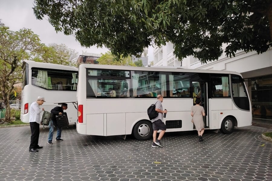 International tour group boarding a private vehicle in Vietnam