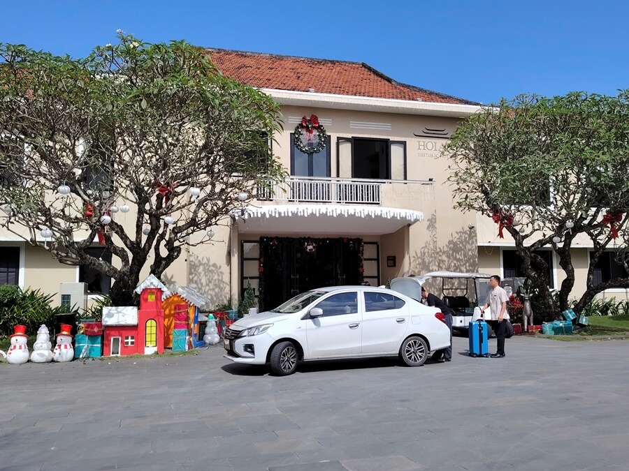 Private car driver helping guests with luggage at a Hoi An hotel drop-off