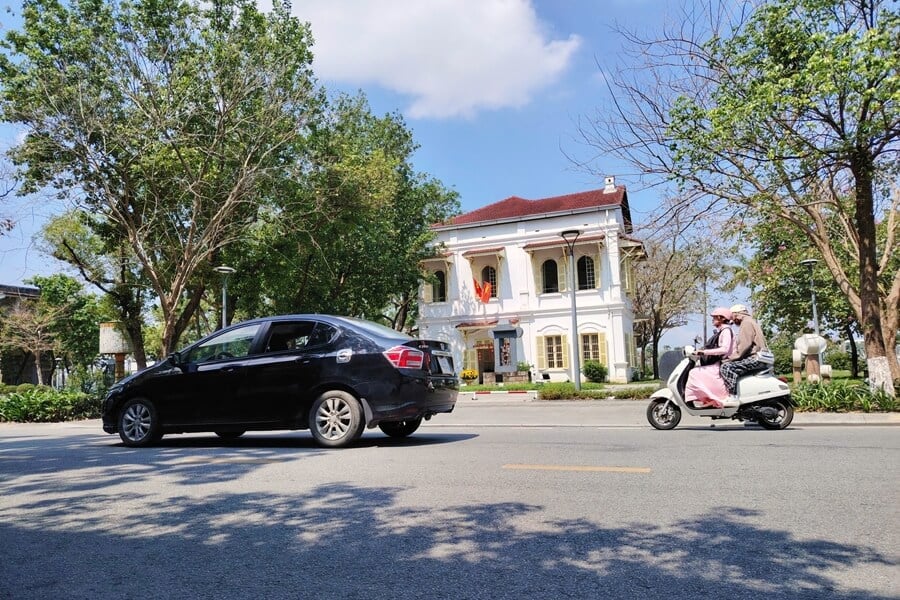 A 4-seat car with driver traveling on Le Loi Street in Hue City