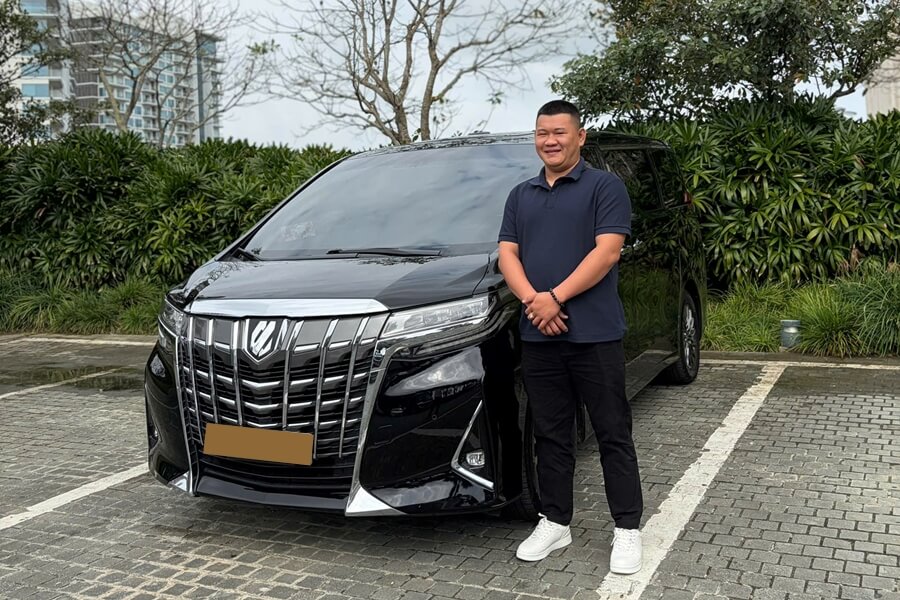 Toyota Alphard with a professional chauffeur at a hotel for VIP conference transportation in Ho Chi Minh City