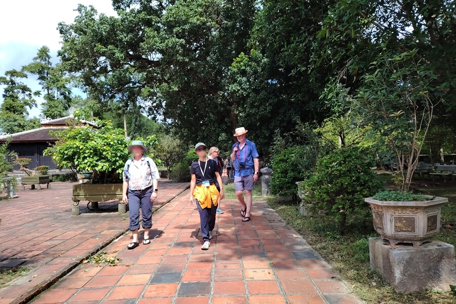 Guests walking under the trees at Thien Mu Pagoda in Hue