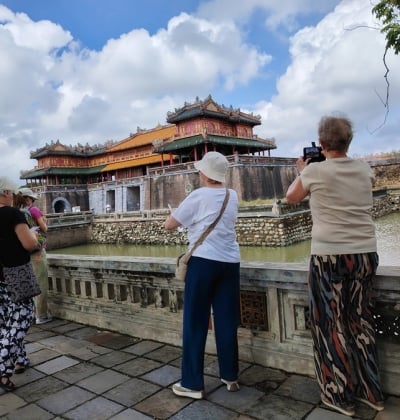 Foreign tourists taking photos at Ngo Mon Gate, Hue Imperial City – a popular stop for private car rental trips from Hoi An